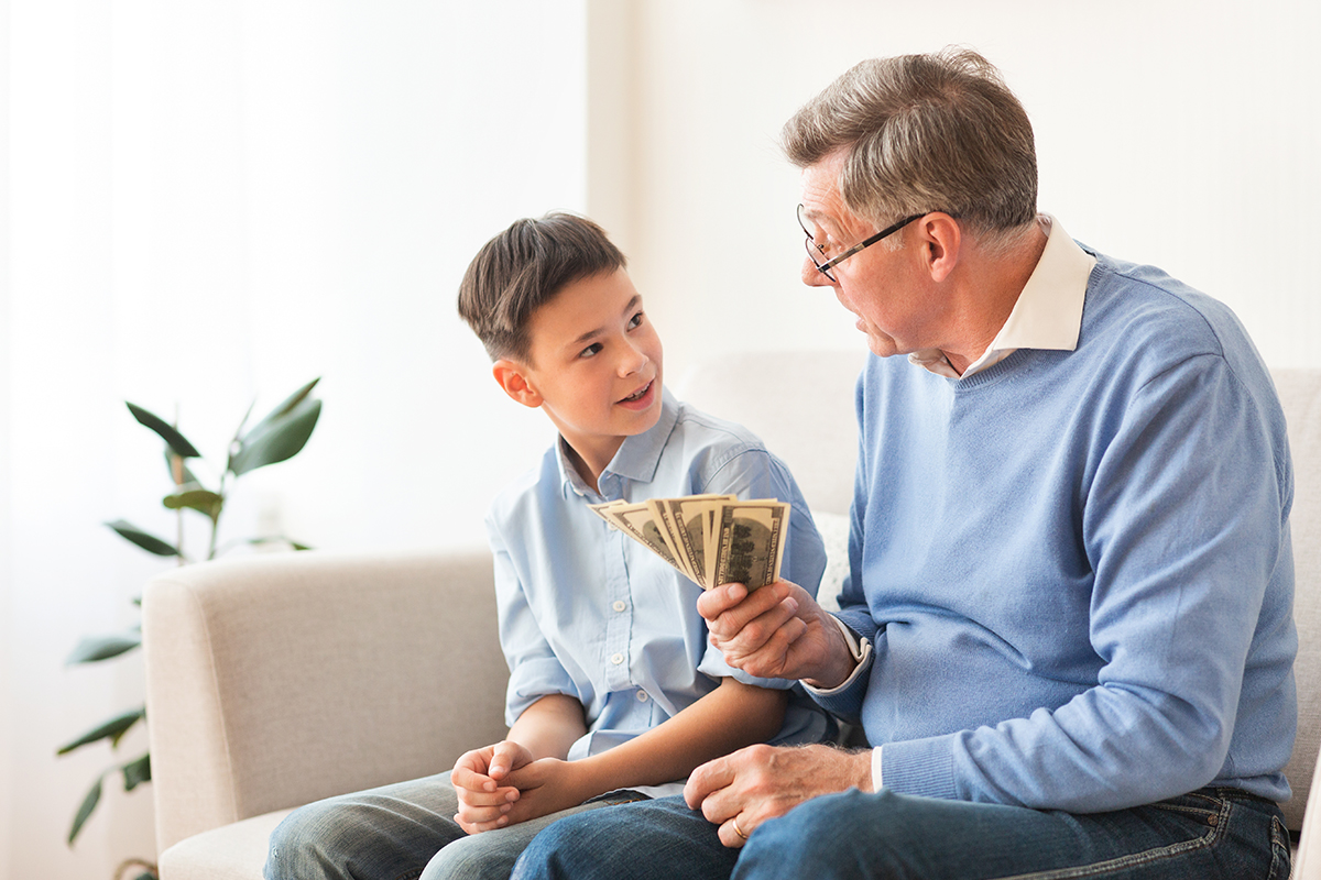 A parent hands her child some bills, which are her allowance. 