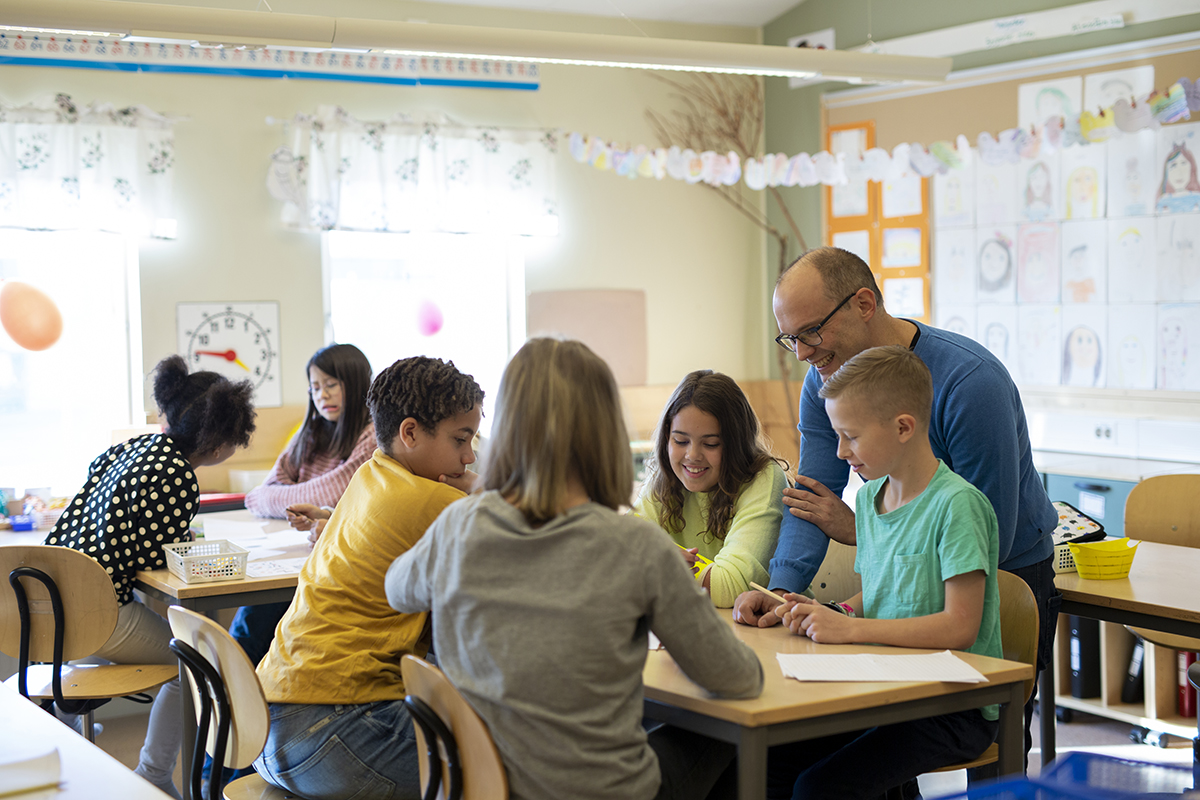 Group of children working as a team inside a classroom. 