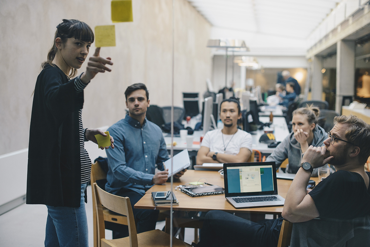PMO - Group of people talking about a project around a table. 