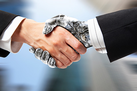 Um robô e uma pessoa a apertarem as mãos. 