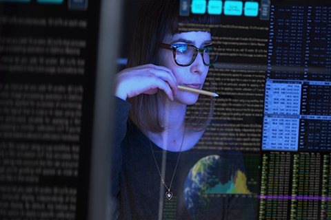 Uma jovem mulher analisa dados fornecidos pela inteligência artificial num ecrã transparente. 