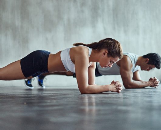 Mulher realiza uma prancha como parte de seus exercícios isométricos. 