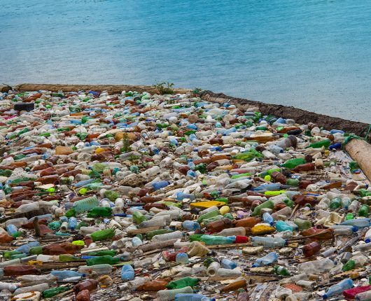 Garrafas plásticas e outros objetos de polietileno flutuando no mar. 