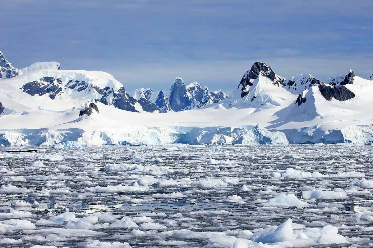 A paisagem antártica mostra várias camadas de gelo derretendo sobre o mar.