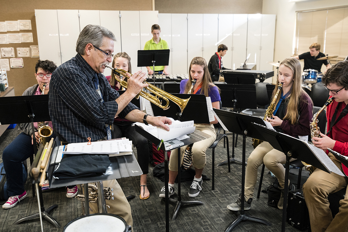 professor de música tocando trompete na aula. 