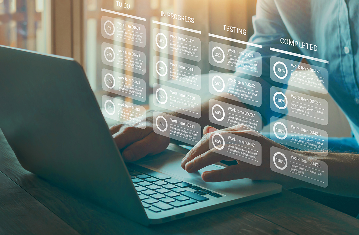 Hombre escribe en su computadora, mientras se muestra un diagrama de flujo con las diferentes tareas de un proyecto y sus respectivos porcentajes alcanzados. 