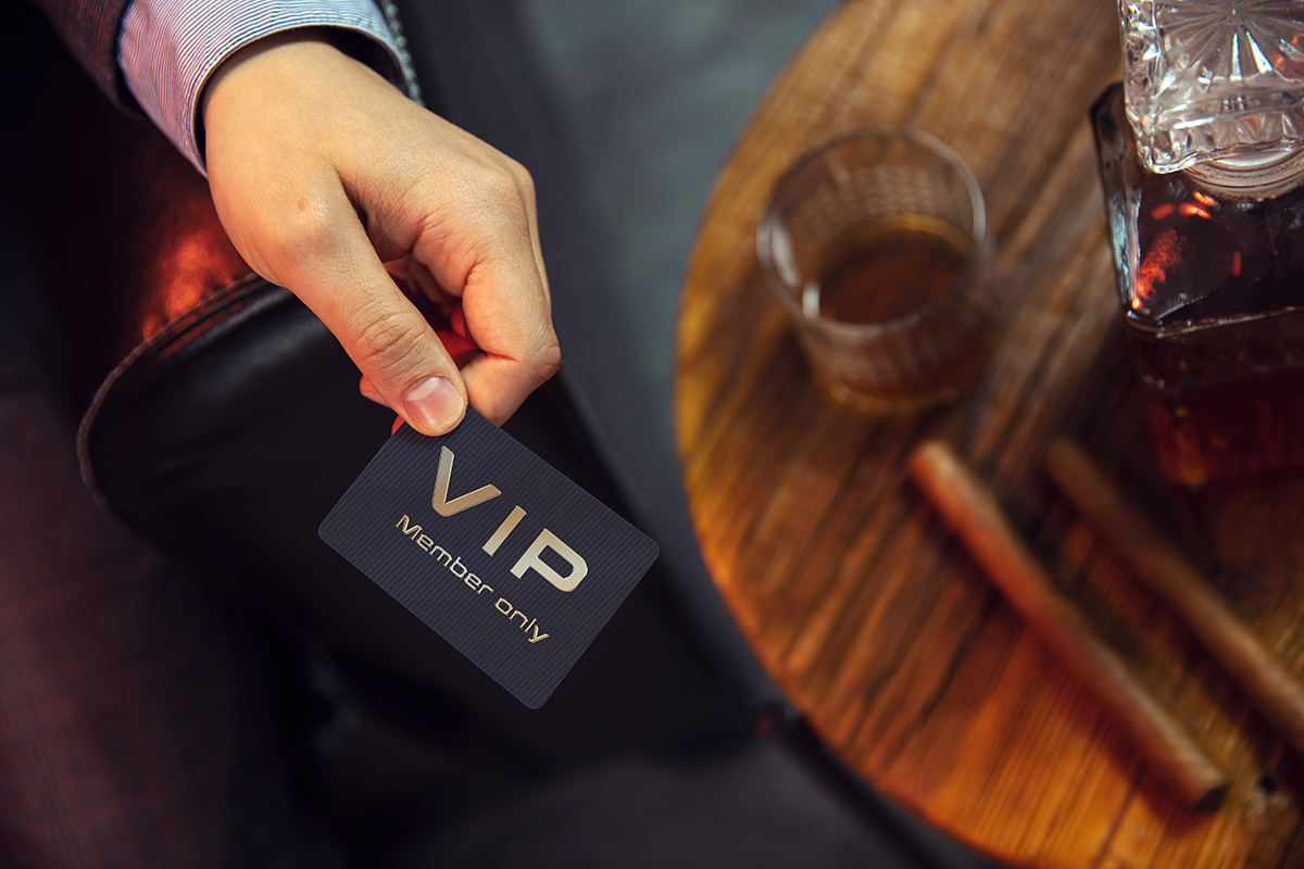 Hombre sostiene en su mano una tarjeta de cliente exclusivo, VIP. 
