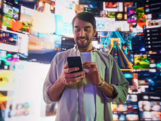 Retrato de un hombre usando un smartphone en ciberespacio 3D con interfaces animadas de redes sociales, videojuegos, vídeos virales, y contenido de internet.